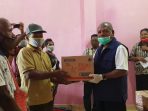 Bupati Jayapura saat menyerahkan bantuan Bama secara simbolik kepada masyarakat Yakonde dampak pembatasan sosial akibat Covid 19 ini.(Foto.Diskominfo Pemkab Jayapura)