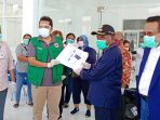 Ketua DPW Partai Nasdem Provinsi Papua didampingi Sekretarisnya saat menyerahkan APD kepada pengurus IDI Wilayah Papua guna disalurkan kepada rumah sakit Yowari dan Dian Harapan.