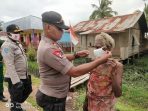 Personil polsek Nambai saat mensosialisasikan 3 M+1 1 T sekaligus memberikan masker kepada masyarakat.( Foto. Humas Polda Papua)