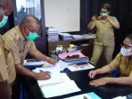 Kadis perumahan, pertanahan dan kawasan permukiman Kabupaten Jayapura saat menandatangani berita acara penyerahan dua gedung olah kepada Kadis Dispora disaksikan Sekda Kabupaten Jayapura.