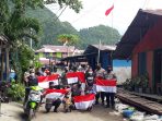 Personil Polsek KPL Jayapura saat berphoto bersama warga Argapura setelah membagikan bendera merah putih dan masker.(Foto. Humas Polresta Jayapura Kota)