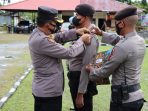Kapolres Waropen AKBP Naharuddin ketika menyematkan pita kepada anggotanya pada pelaksanaan operasi zebra cartenz 2021. (Foto. Humas Polres Waropen)