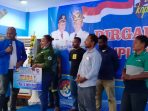 Ketua KNPI Kabupaten Jayapura saat menyerahkan kepada perwakilan juara pertama lomba voli Putri sekaligus uang pembinaan pada syukuran HUT KNPI Ke-48.