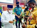 Ketua Gapura Kabupaten Jayapura saat menyerahkan cenderamata berupa topi bulu kasuari dari Kabupaten Jayapura & Noken ketika bertemu dengan Wapres.(Foto. Istimewa)