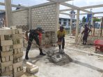 Babinsa saat membantu warga membangun rumah milik Arnol Baransano .(Foto. Pendam XVIICenderawasih)