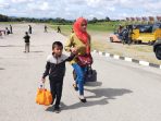 Seorang Ibu sambil memegang anaknya. Mereka merupakan warga Oksibil saat tiba dilapangan Base Ops Lanud Silas Papare setelah menumpang pesawat Hercules milik TNI.