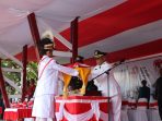 Wakil Bupati Waropen Lamek Maniagasi, SE saat menerima Dupllikat merah putih dari pembawa baki usai Penurunan bendera.(Foto.Rich)