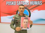 Kasatgas Humas Damai Cartenz saat menunjukkan photo pilot berkewarnegaaan Selandia Baru setelah sebelumnya disandera kemudian dibunuh.(Foto. Humas Damai Cartenz)