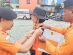 Kakansar Biak saat menyematkan pita kepada 2 peserta pelatihan dasar Sar.  