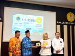 Ketua Yayasan didampingi kepsek SMKS YPKP TIK Sentani saat menyerahkan cinderamata kepada dekan FIB Unsoed disela-sela kunjungan inisiasi ke Unsoed kemarin.